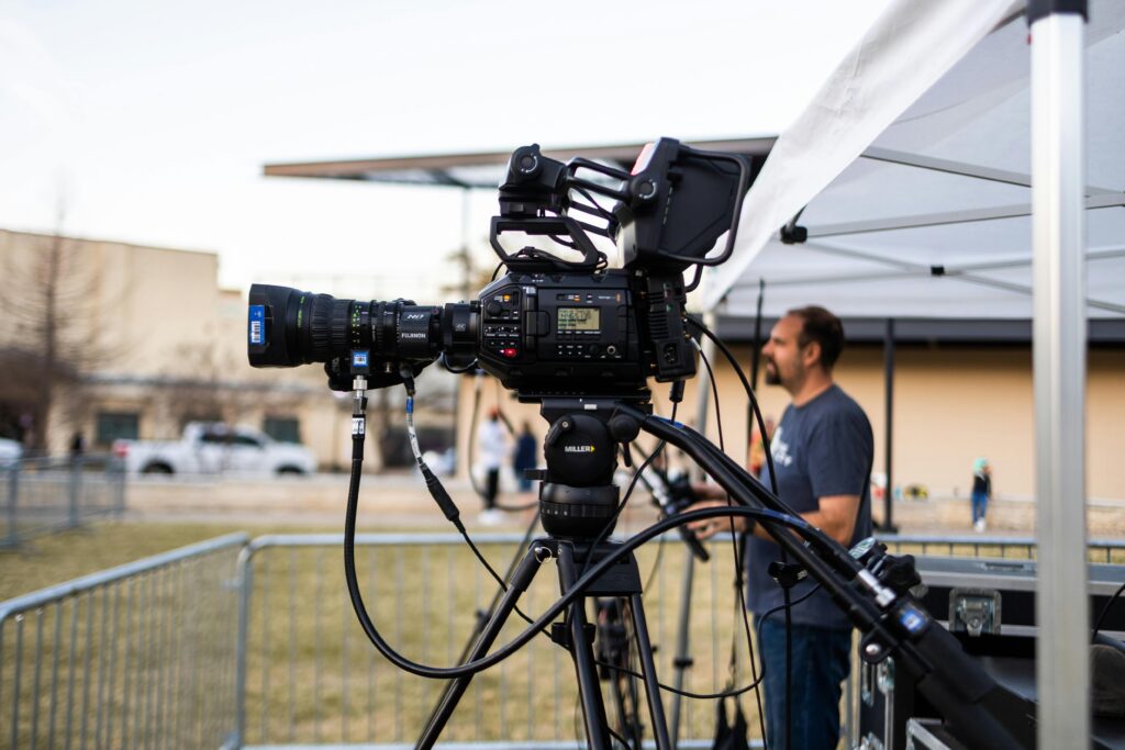 video camera on a tripod outside filming event